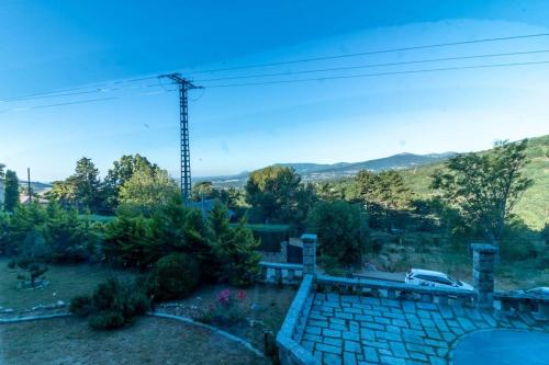 a view of a yard with a car in the distance at Espectacular vista en la fuenfria in Cercedilla