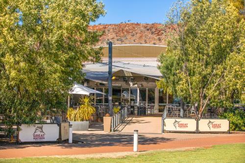 a restaurant with trees in front of a building at Crowne Plaza Alice Springs Lasseters by IHG in Alice Springs