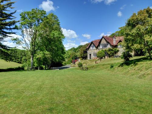 a house on a hill with a large grass field at YHA Beer in Seaton
