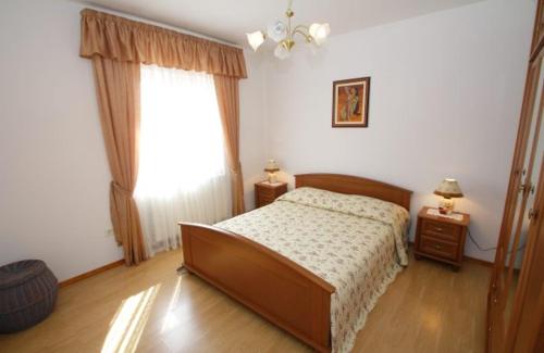 a bedroom with a bed and a large window at Holiday Apartment Ori in Nedeščina