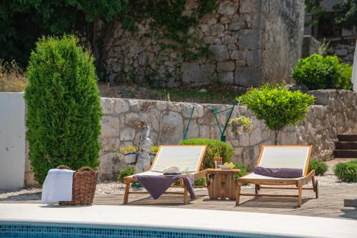 two chairs and a table next to a swimming pool at Traditional Comfort Casa Natura with 36m2 Pool in Slivno