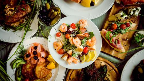 a table full of plates of food with shrimp on them at Kolonna Hotel Brigita in Rīga