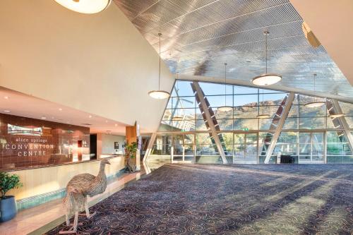 a large lobby with a peacock in the middle of a building at Crowne Plaza Alice Springs Lasseters by IHG in Alice Springs