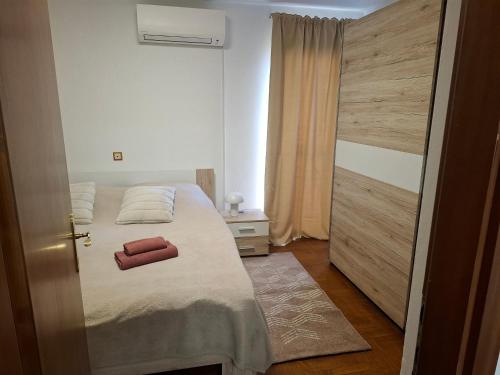 a bedroom with a bed and a wooden door at Apartmani Delas 2 in Pješčana Uvala 
