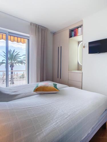 une chambre blanche avec un lit et une grande fenêtre dans l'établissement Une véritable perle 342L HUI, à Cannes
