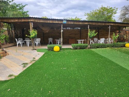 a yard with chairs and tables and a pavilion at Foundation Stones Lodge Mafikeng in Mahikeng