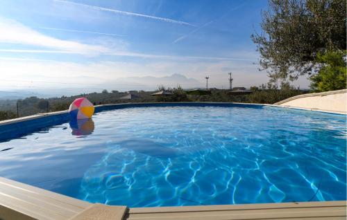 a swimming pool with a beach ball and an umbrella at Pet Friendly Apartment In Moscufo in Moscufo