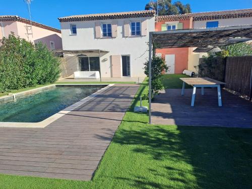 une arrière-cour avec une piscine et une table en face d'une maison dans l'établissement Gridelaide26 - Les jardins d'Adelaïde - Grimaud - Golfe de Saint-Tropez - Villa avec piscine privée proche de la mer, à Grimaud