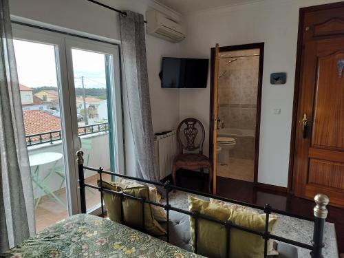 a bedroom with a bed and a view of a bathroom at Xixi Cama Bed & Breakfast in Bombardeira