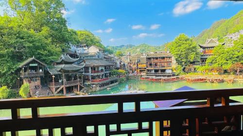 a view of a town with a river and buildings at LQJ Riverside Guest House in Fenghuang