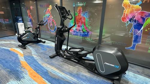 a gym with two exercise bikes in front of a wall at Holiday Inn Express Zhengzhou Zhengdong by IHG in Zhengzhou