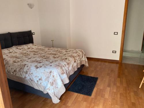a bedroom with a bed and a wooden floor at 4routes house in Salerno