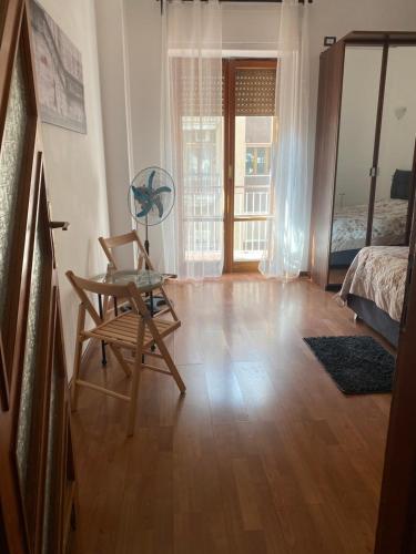 a room with a table and a chair and a bedroom at 4routes house in Salerno