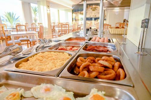 a buffet line with different types of food in trays at Hotel Ibiza Playa in Ibiza Town