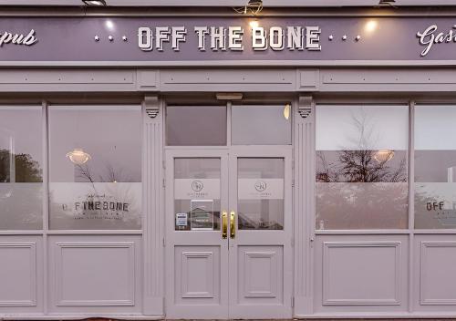 a store front with doors and a sign that reads off the bone at Great National South Court Hotel in Limerick