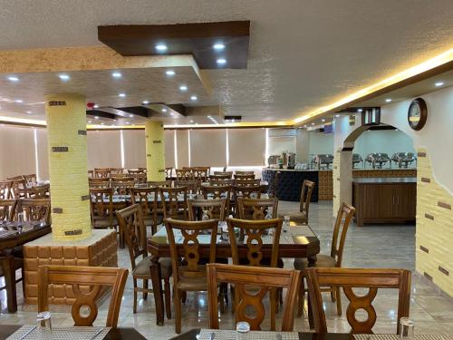 a dining room filled with wooden tables and chairs at Sunset Hotel in Wadi Musa