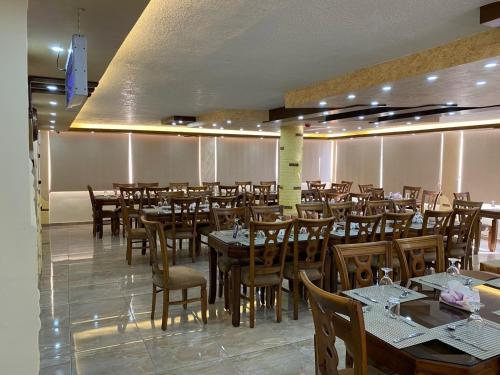 a dining room with wooden tables and chairs at Sunset Hotel in Wadi Musa