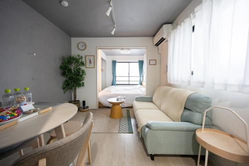 a living room with a couch and a bed at Stellar Nishi-Kojiya in Tokyo