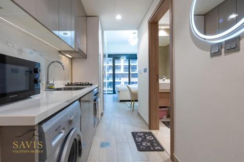 una cocina con fregadero y lavavajillas en Savis Homes - Azizi Riviera 43 - Chic Studio Near Downtown and Business Bay, en Dubái