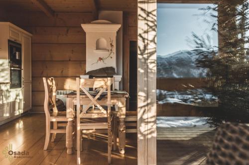 a dining room with a table and chairs and a window at Osada Kościelisko - Tatry na Wyciągnięcie Ręki in Kościelisko