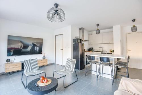 une cuisine et un salon avec une table et des chaises dans l'établissement Le Vallon - Bel appart 2 ch avec terrasse, à Marseille