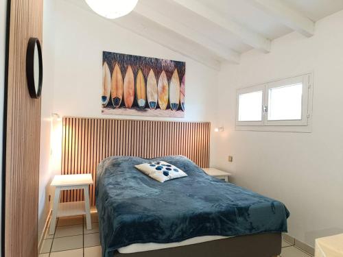 - une chambre avec un lit et des planches de surf sur le mur dans l'établissement T2 climatisé à 2 minutes de la plage du Pont Tournant - 4BRANR, à Saint Cyprien Plage