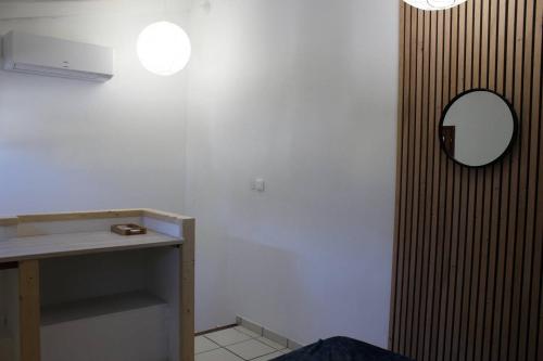 une salle de bain avec un lavabo et un miroir au mur dans l'établissement T2 climatisé à 2 minutes de la plage du Pont Tournant - 4BRANR, à Saint Cyprien Plage