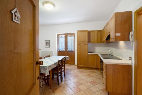 a kitchen with a table with chairs and a counter top at Residence Malibu Appartamento 4 in Falcade