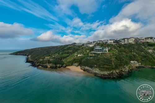 an island in the water with condos on it at The Lucky Shamrock Caravan - by stunning, Crantock Beach in Crantock