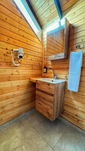 a bathroom with a sink in a wooden wall at Luna Home Club in Samandağı