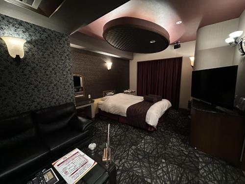 a hotel room with a bed and a couch at ホテルk2 in Itoshima