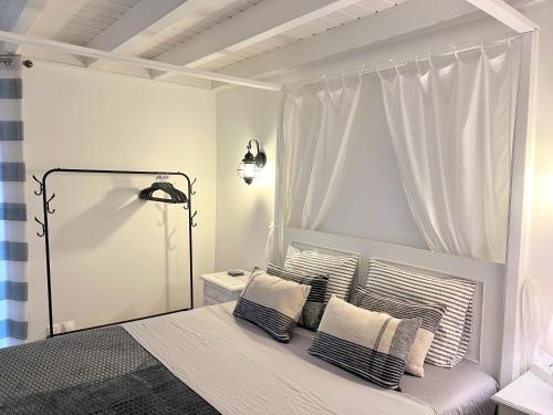 a white bedroom with a bed with two pillows at Casa Baleia Laranja Ocean-Front in Madalena