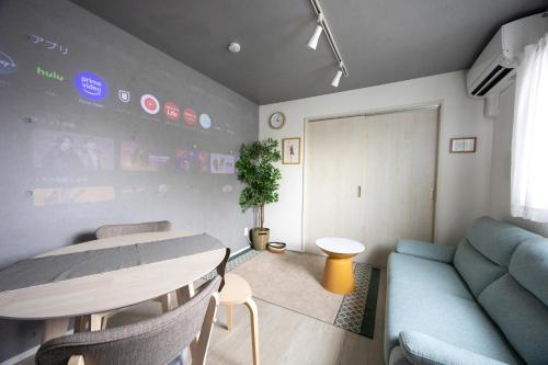 a living room with a table and a blue couch at Stellar Nishi-Kojiya in Tokyo