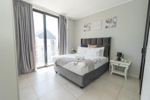 a bedroom with a bed with a teddy bear on it at Casa Bella in Summerstrand
