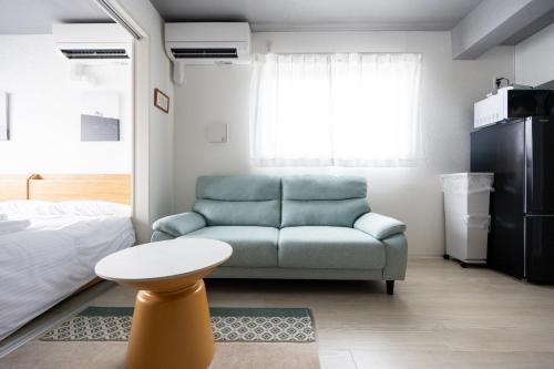 a living room with a couch and a bed at Stellar Nishi-Kojiya in Tokyo