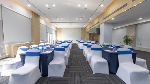 a conference room with white tables and blue chairs at Holiday Inn Express Chengdu Wuhou New City by IHG in Chengdu