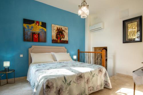 a bedroom with a bed with a blue wall at Tramonto sul Lago in Passignano sul Trasimeno