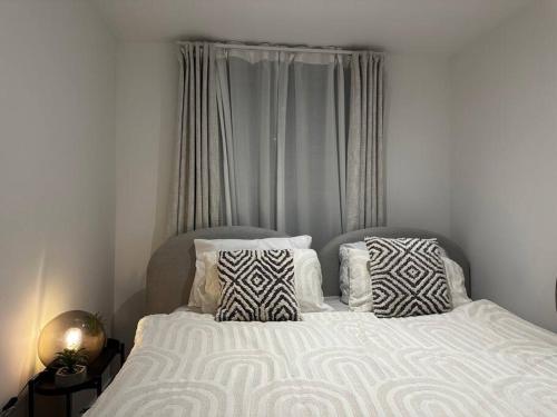 Un dormitorio con una cama blanca con almohadas. en Eastbourne Central Apartment Short and Long Stay welcome, en Eastbourne