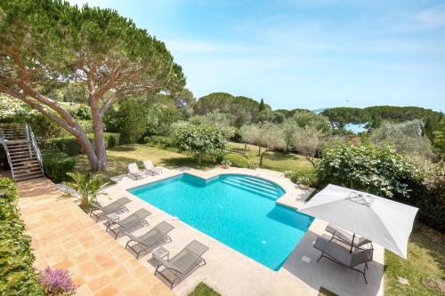 une piscine avec des chaises et un parasol dans l'établissement Villa Capilla, sea view, à Saint-Tropez