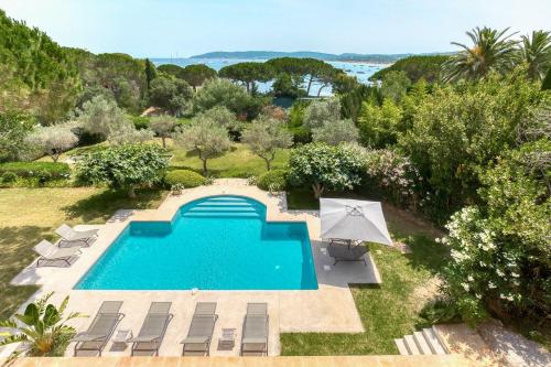 - une vue sur la piscine avec des chaises et un parasol dans l'établissement Villa Capilla, sea view, à Saint-Tropez