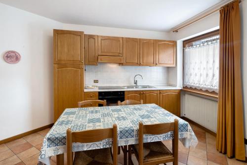 a kitchen with a table and chairs and a sink at Residence Malibu Appartamento 8 in Falcade