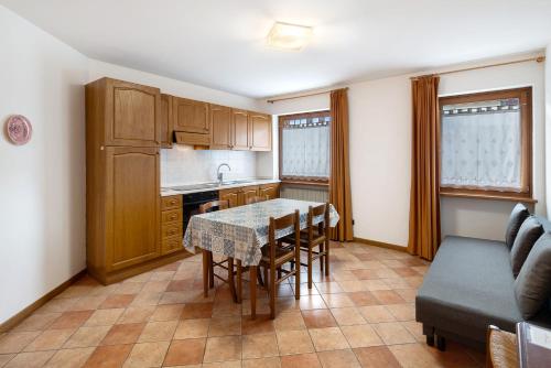 a kitchen with a table and chairs and a couch at Residence Malibu Appartamento 8 in Falcade