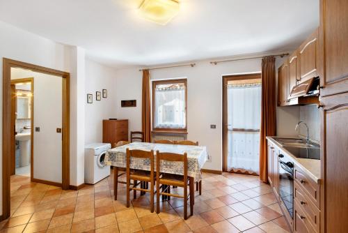 a kitchen and dining room with a table and chairs at Residence Malibu Appartamento 5 in Falcade