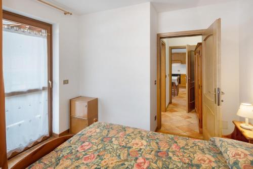 a bedroom with a bed and a large window at Residence Malibu Appartamento 5 in Falcade