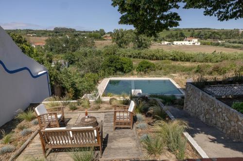 a patio with chairs and a swimming pool at Arneiro Garden House - Country Retreat with BioPool in Alenquer