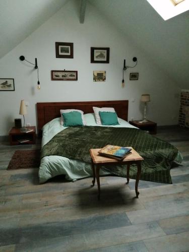 une chambre avec un grand lit et une table dans l'établissement La Chèvrerie de Saint-Vigor, à Saint-Vigor-dʼYmonville