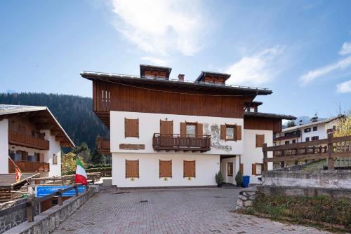 a building with a balcony on the side of it at Residence Malibu Appartamento 2 in Falcade