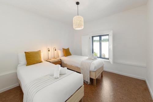 a white room with two beds and a window at Arneiro Garden House - Country Retreat with BioPool in Alenquer