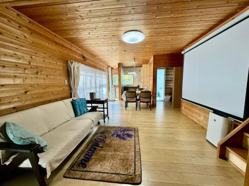 a living room with a couch and a big screen tv at Stella Rental Villa Engawa House in Fujikawaguchiko