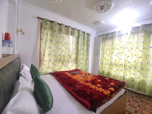 a bedroom with a bed and two windows with curtains at Betab Valley Guest House Pahalgam in Pahalgām